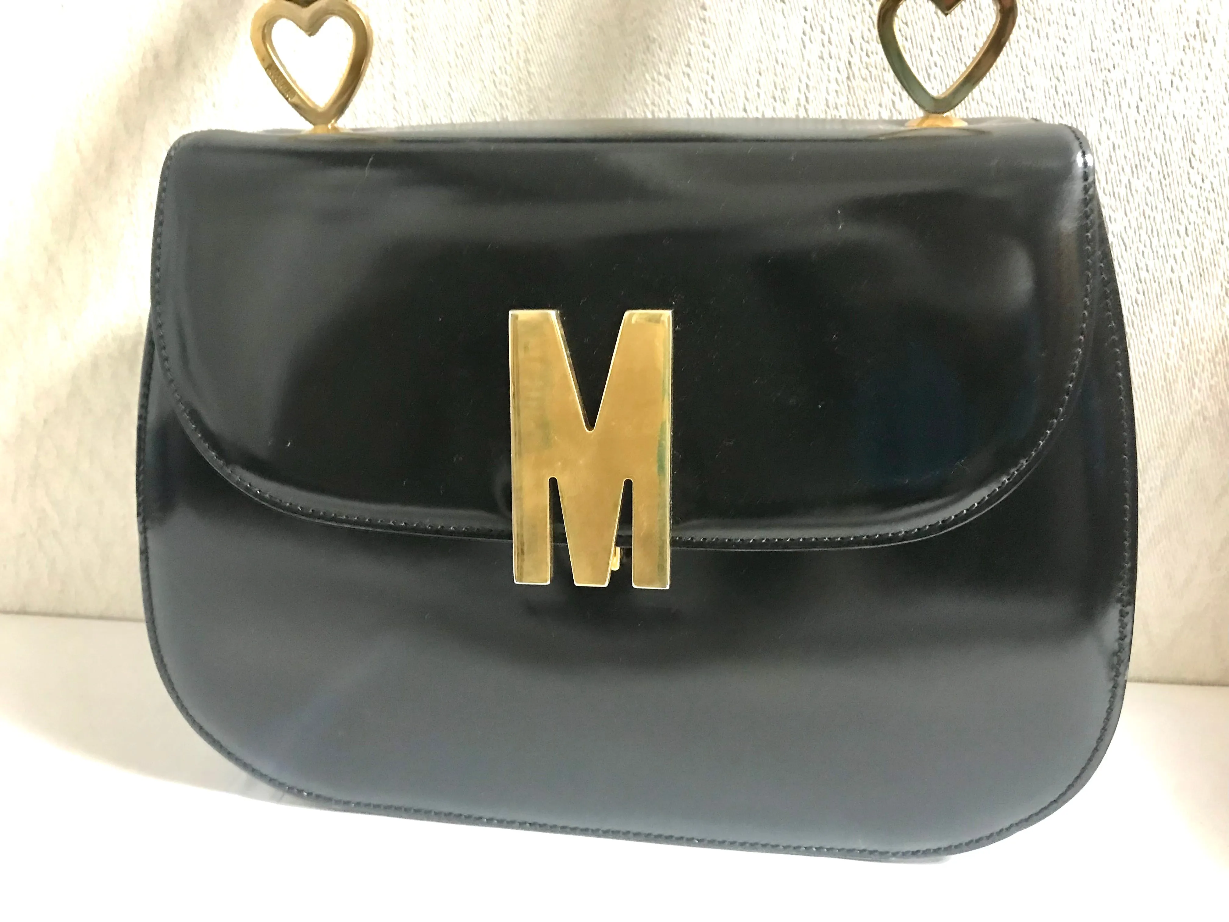 Vintage MOSCHINO black patent enamel Kelly style handbag with M logo and heart motifs. Masterpiece by Redwall. 050323re4
