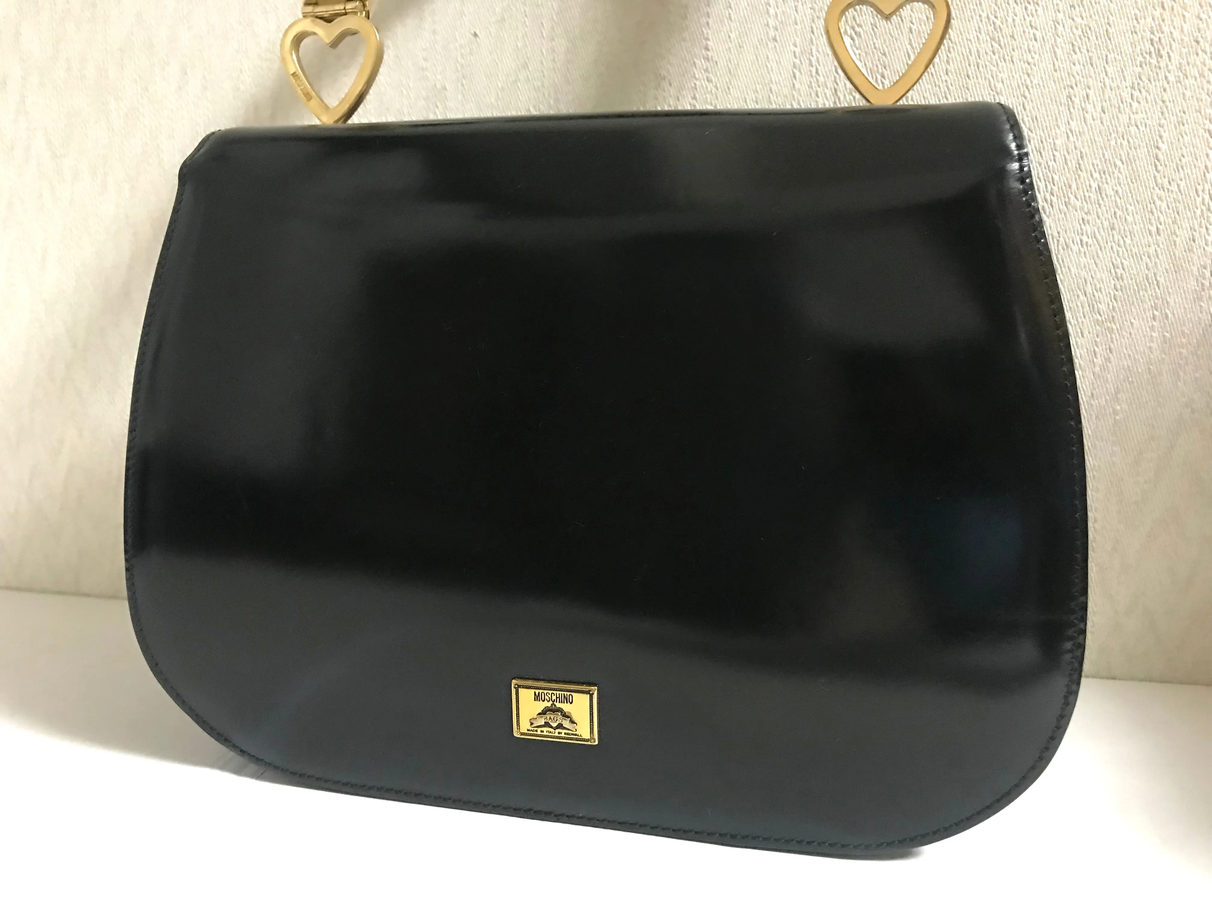 Vintage MOSCHINO black patent enamel Kelly style handbag with M logo and heart motifs. Masterpiece by Redwall. 050323re4